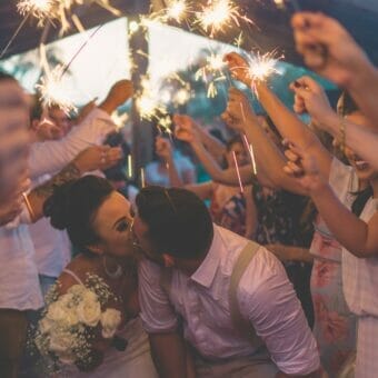 newly wed kissing surrounded by people